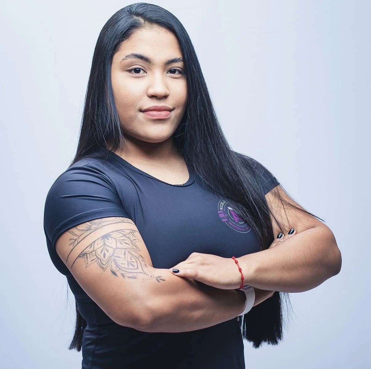 Nicolly Almeida, personal trainer, com os braços cruzados